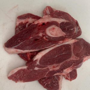 Lamb Shoulder Chops (1lb) for sale is laying on top of a white surface.