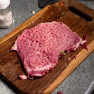 Beef Cubed Steak (1lb) on a cutting board.