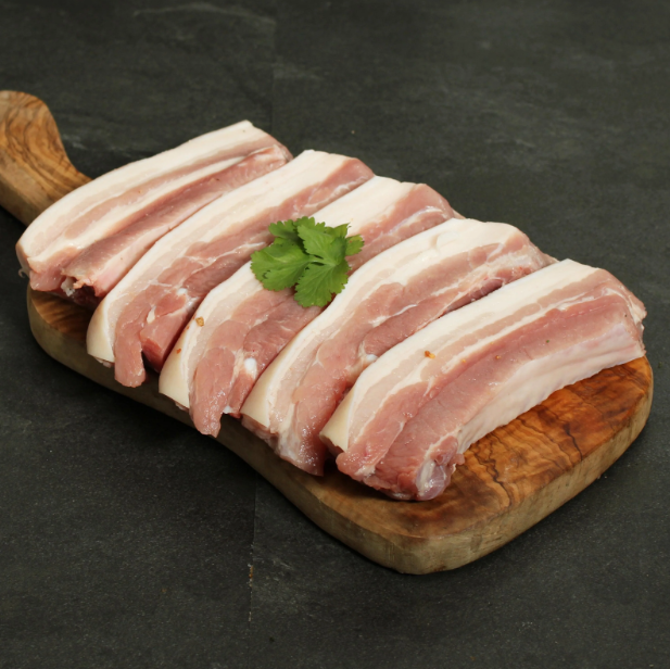 Sliced raw bacon arranged neatly on a wooden cutting board, garnished with a single cilantro leaf, on an auto draft dark grey surface.